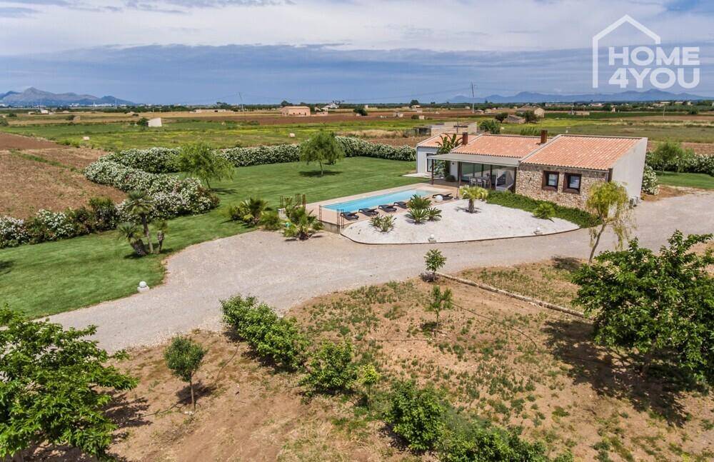 Luftaufnahme des Hauses mit Poolbereich, Kiesauffahrt und umgebender ländlicher Landschaft.