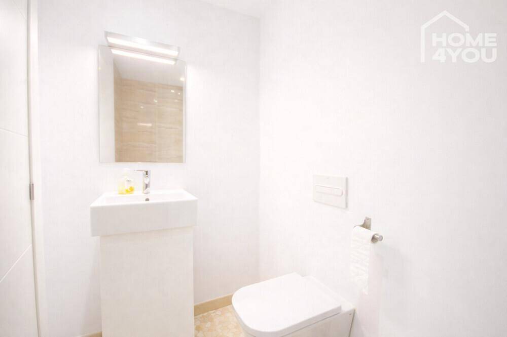 Modernes Gäste-WC mit wandhängender Toilette und minimalistischem Waschbecken.
