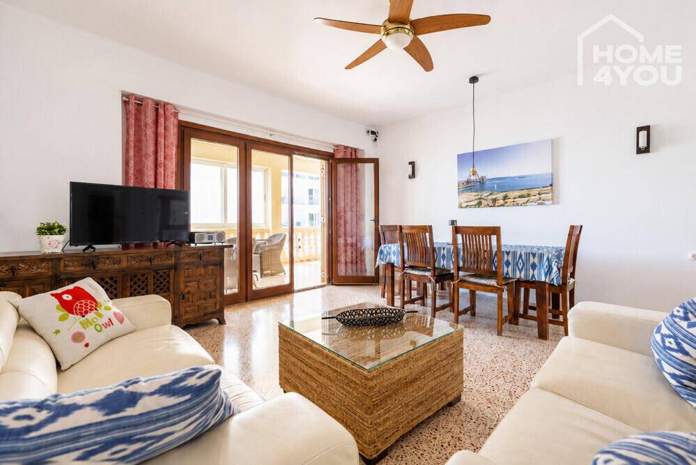Heller Wohn-Essbereich mit bequemen Sofas, Esstisch und Zugang zum Balkon.