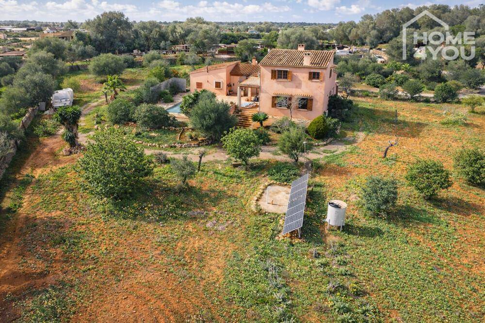 Panoramablick auf das Landhaus mit Pool, umgeben von mediterraner Vegetation und Solaranlagen.