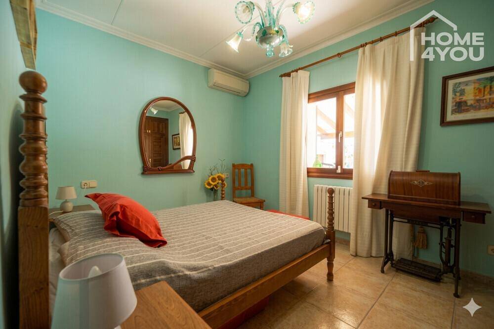 Helles Schlafzimmer mit Holzbett, Spiegel und Klimaanlage, dekoriert in hellblauen Tönen.