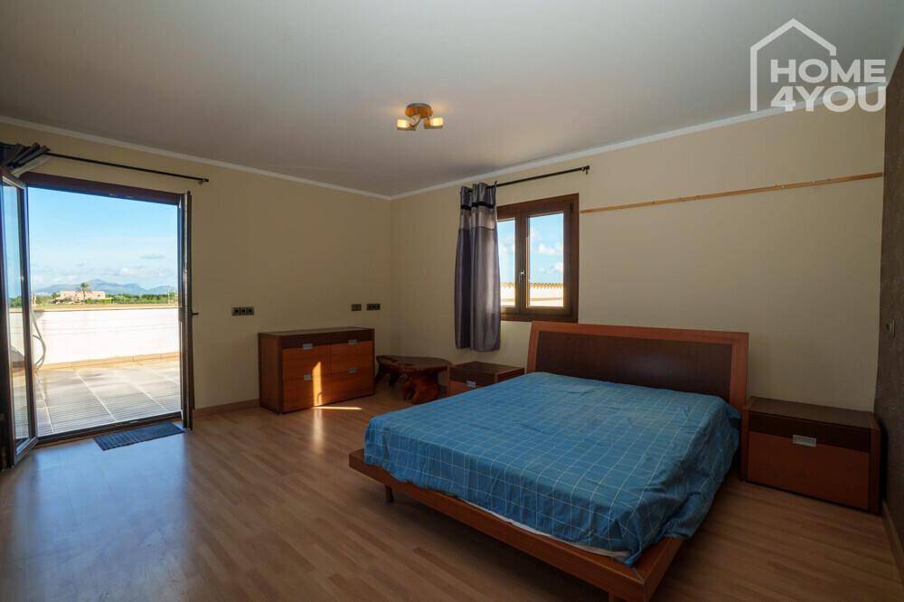 Schlafzimmer mit direktem Zugang zu einer großen Terrasse, ideal für entspannte Morgenstunden.