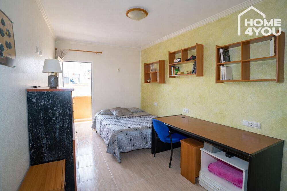 Gemütliches Schlafzimmer mit Einzelbett, Schreibtisch und Wandregalen, ideal als Gästezimmer.
