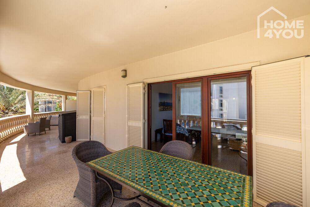 Geräumiger Balkon mit Esstisch und Zugang zum Innenbereich.