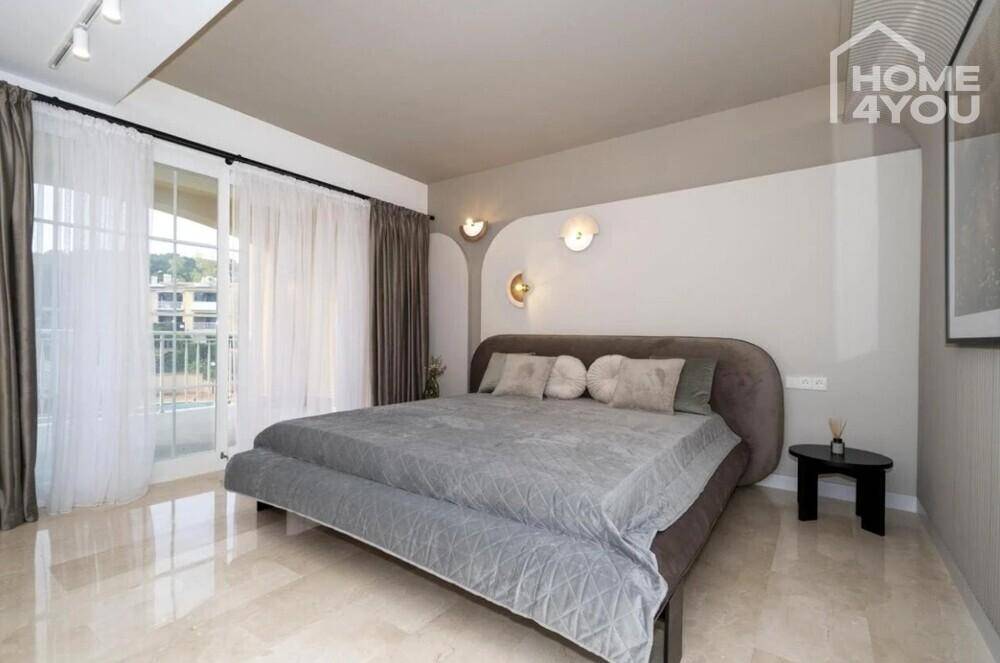 Geräumiges Schlafzimmer mit großem Bett, stilvoller Einrichtung und Blick nach draußen.