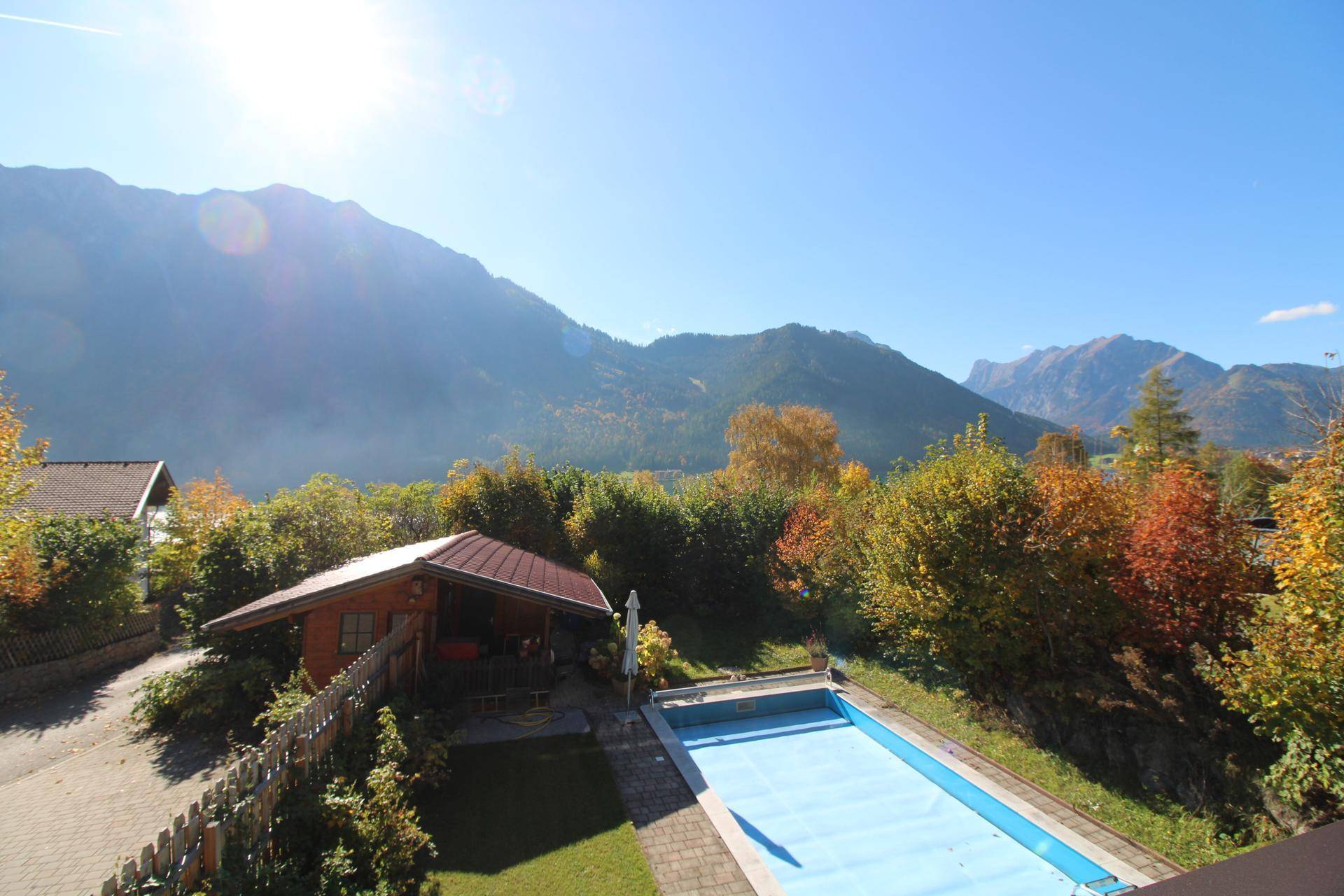 Panoramablick auf das Anwesen mit Pool, Garten und der umliegenden Berglandschaft.