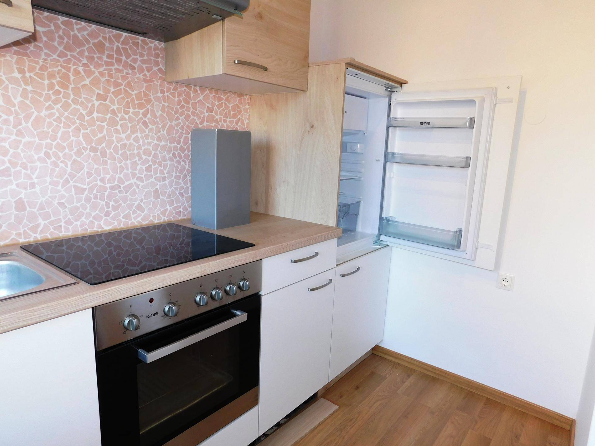 Moderne Küche mit integriertem Kühlschrank, Induktionskochfeld und Backofen.