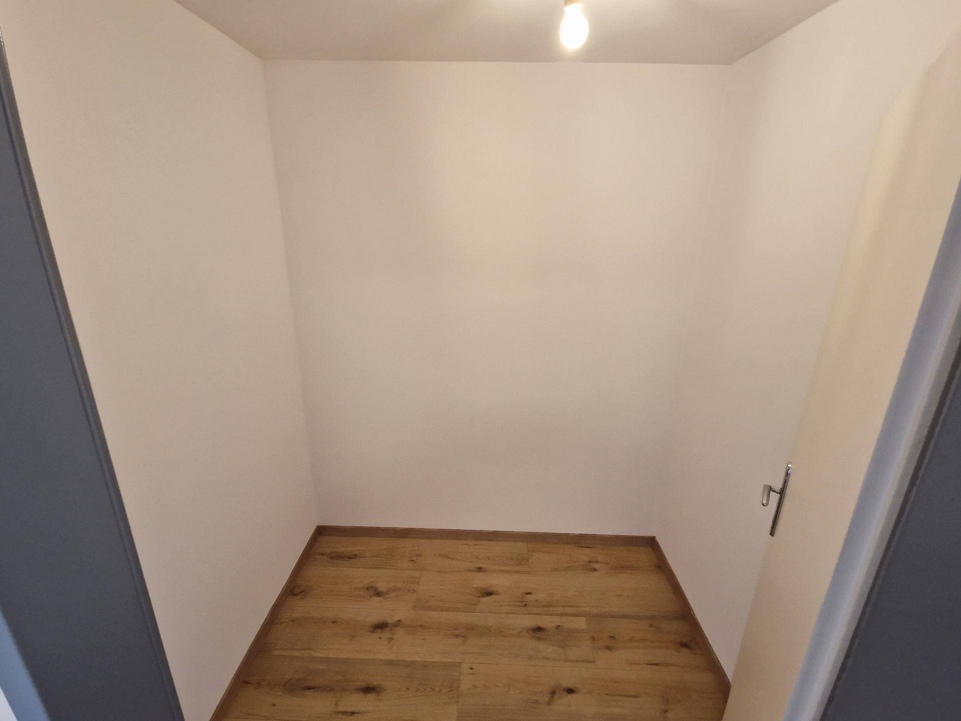 Kleiner, leerer Abstellraum mit Laminatboden und weißen Wänden, ideal für zusätzlichen Stauraum.