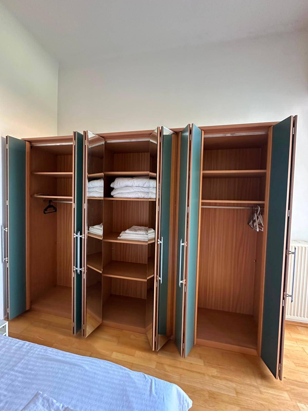 Offener Kleiderschrank im Schlafzimmer mit viel Stauraum und Ablagemöglichkeiten.