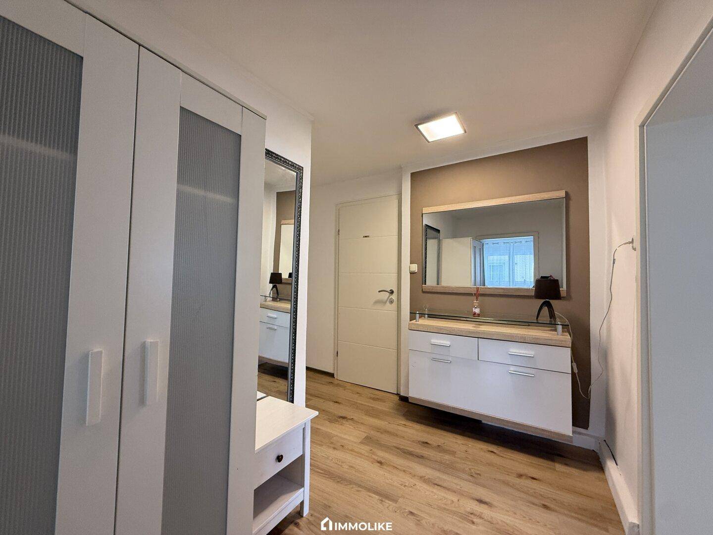 Eingangsbereich mit Garderobe, Spiegel und Laminatboden.