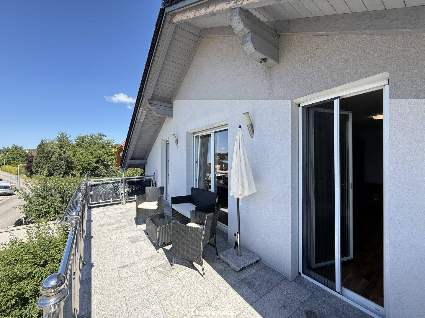 Geräumiger Balkon mit Sitzgelegenheiten und Blick auf die Umgebung, ideal zum Entspannen.