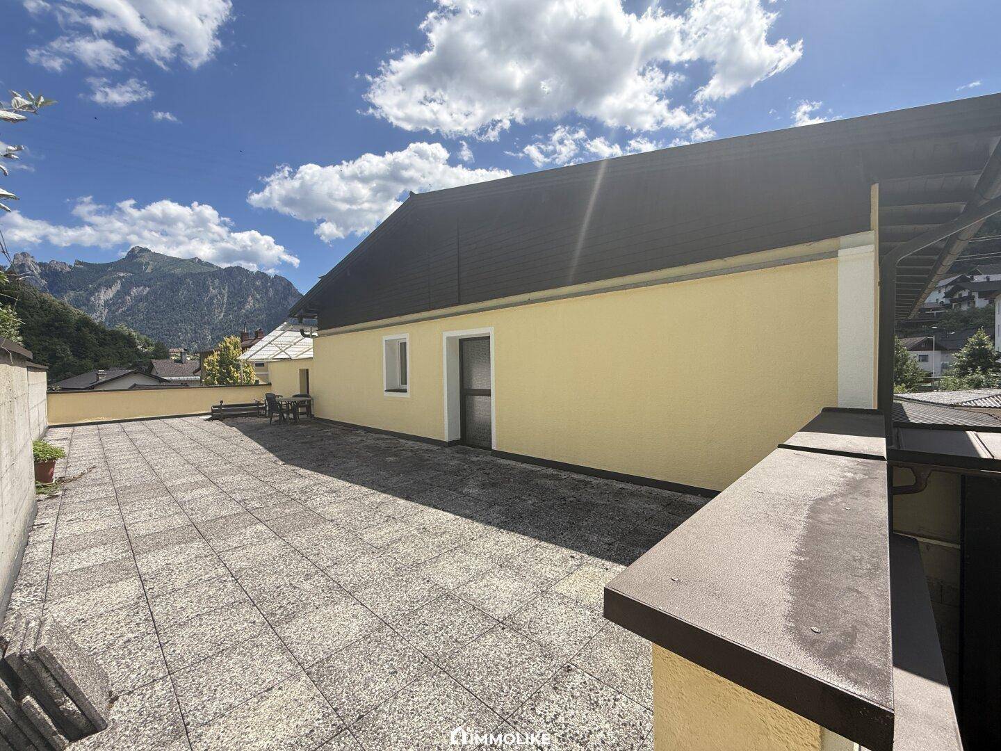 Große gepflasterte Terrasse mit Bergblick, ideal für Entspannung im Freien.