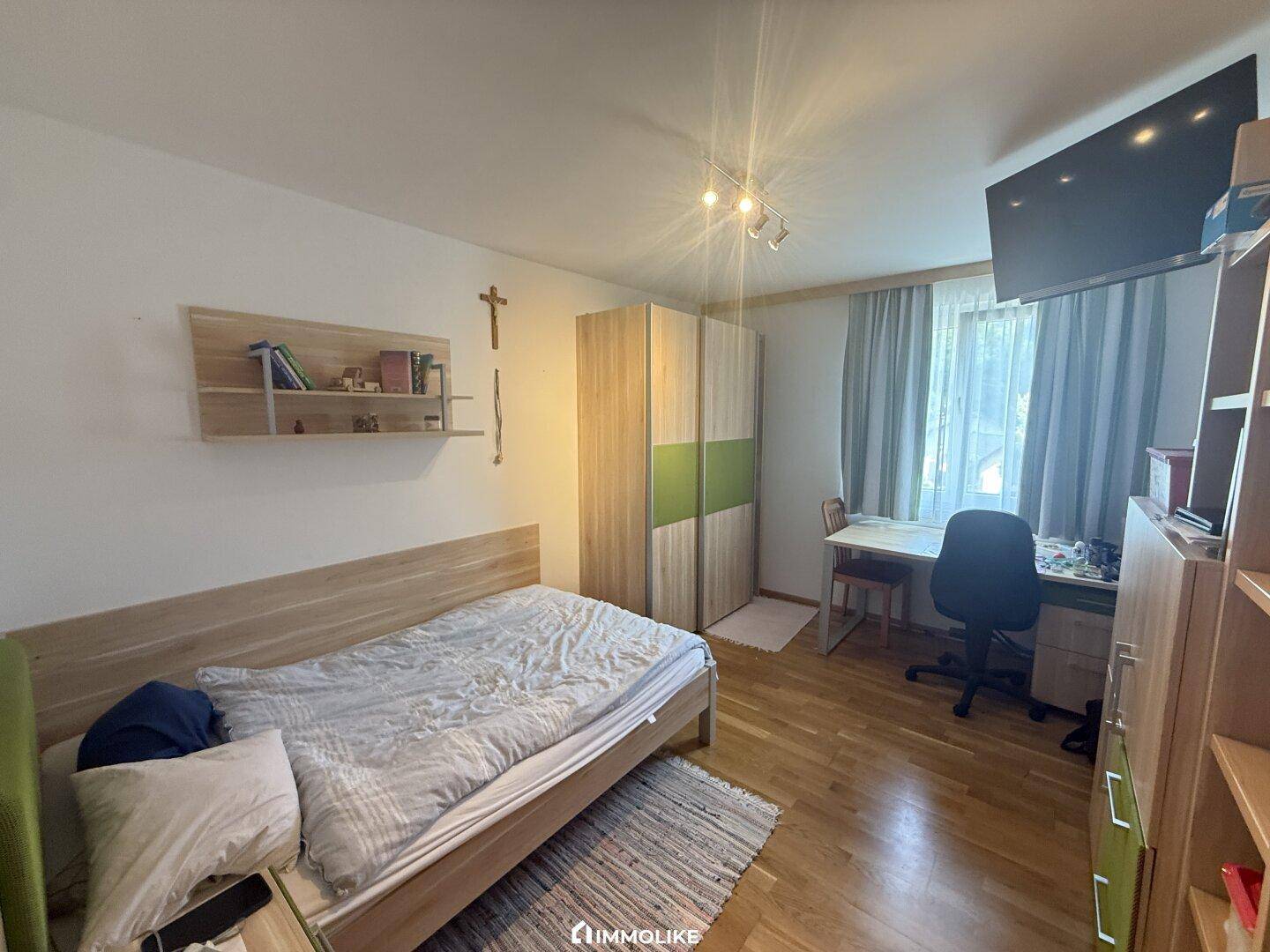 Gemütliches Schlafzimmer mit Einzelbett, Schreibtisch und Kleiderschrank, ideal als Kinder- oder Gästezimmer.