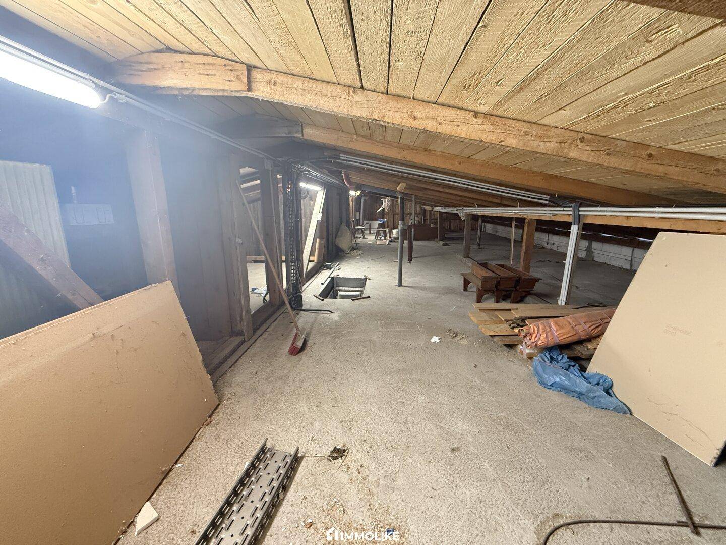 Unausgebauter Dachboden mit sichtbaren Holzbalken und viel Stauraum, bietet Ausbaupotenzial.