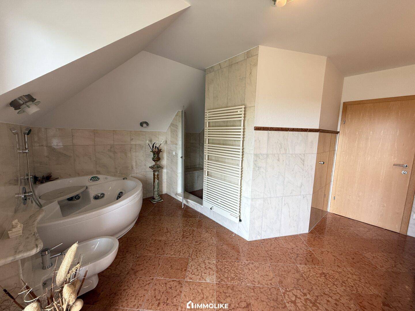 Luxuriöses Badezimmer mit Eck-Whirlpool, separater Dusche und beheiztem Handtuchhalter.