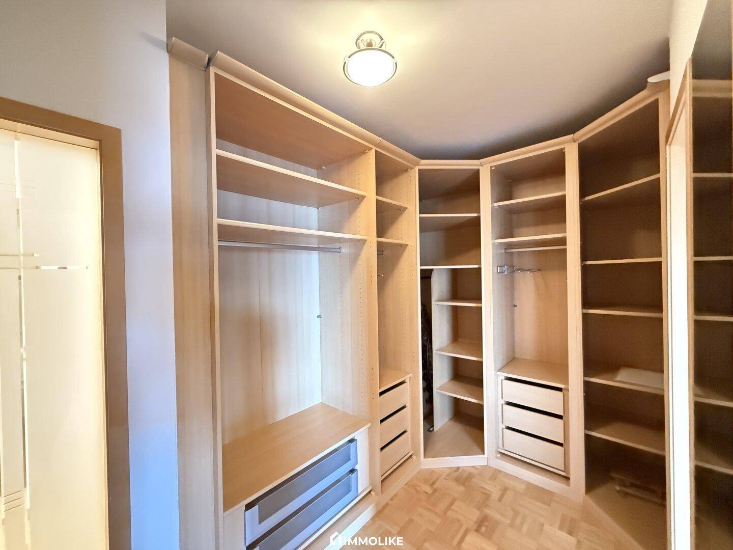 Begehbarer Kleiderschrank mit maßgefertigten Regalen und Schubladen für optimale Organisation.