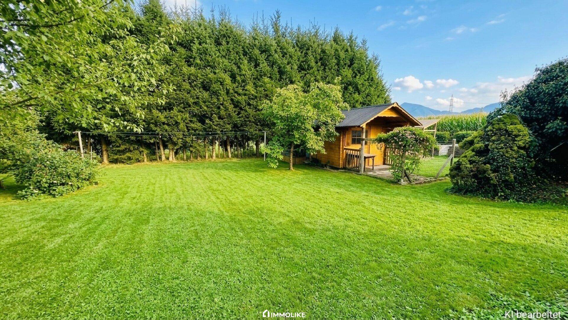 Großer Garten mit Rasenfläche und einem charmanten Gartenhaus aus Holz.