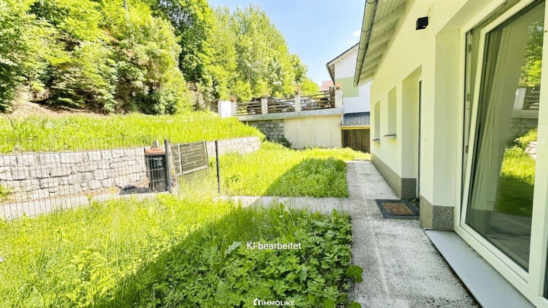 Seitlicher Außenbereich des Hauses mit Grünfläche und Zugang zum Garten.