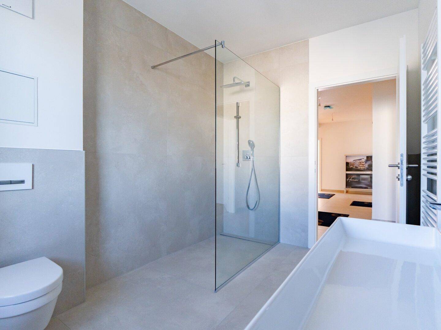 Modernes Badezimmer mit begehbarer Dusche, Wand-WC und hellen Fliesen.
