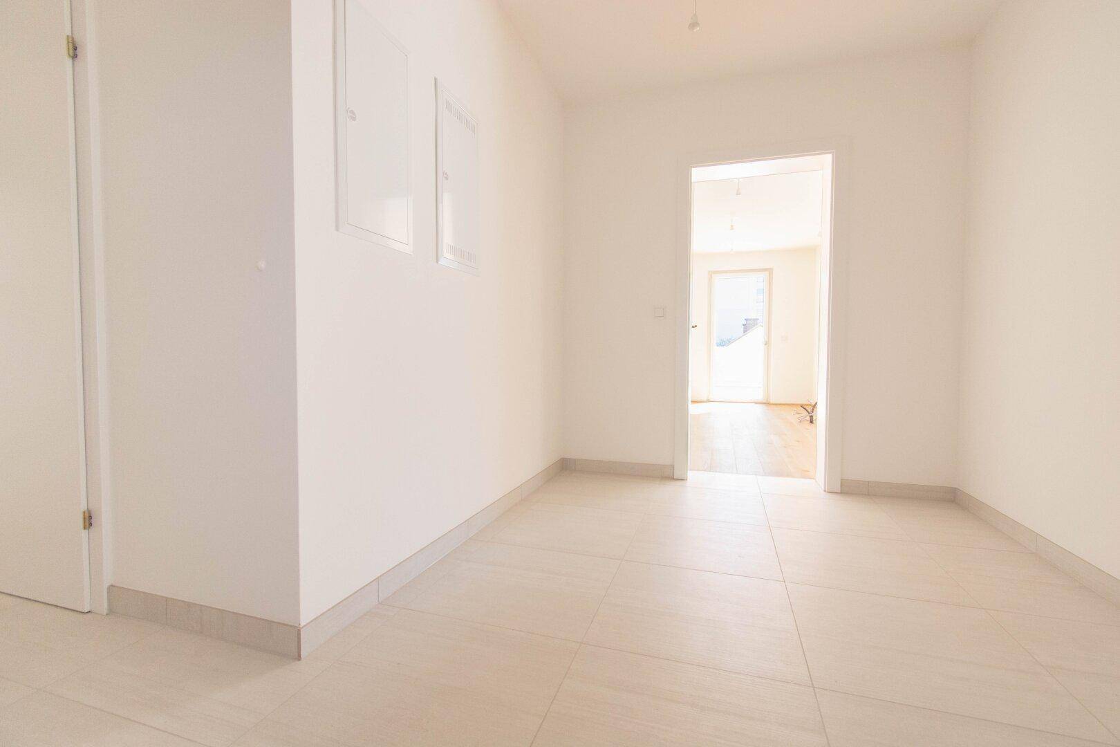 Heller Eingangsbereich mit Fliesenboden, der zu den Wohnräumen der Wohnung führt.
