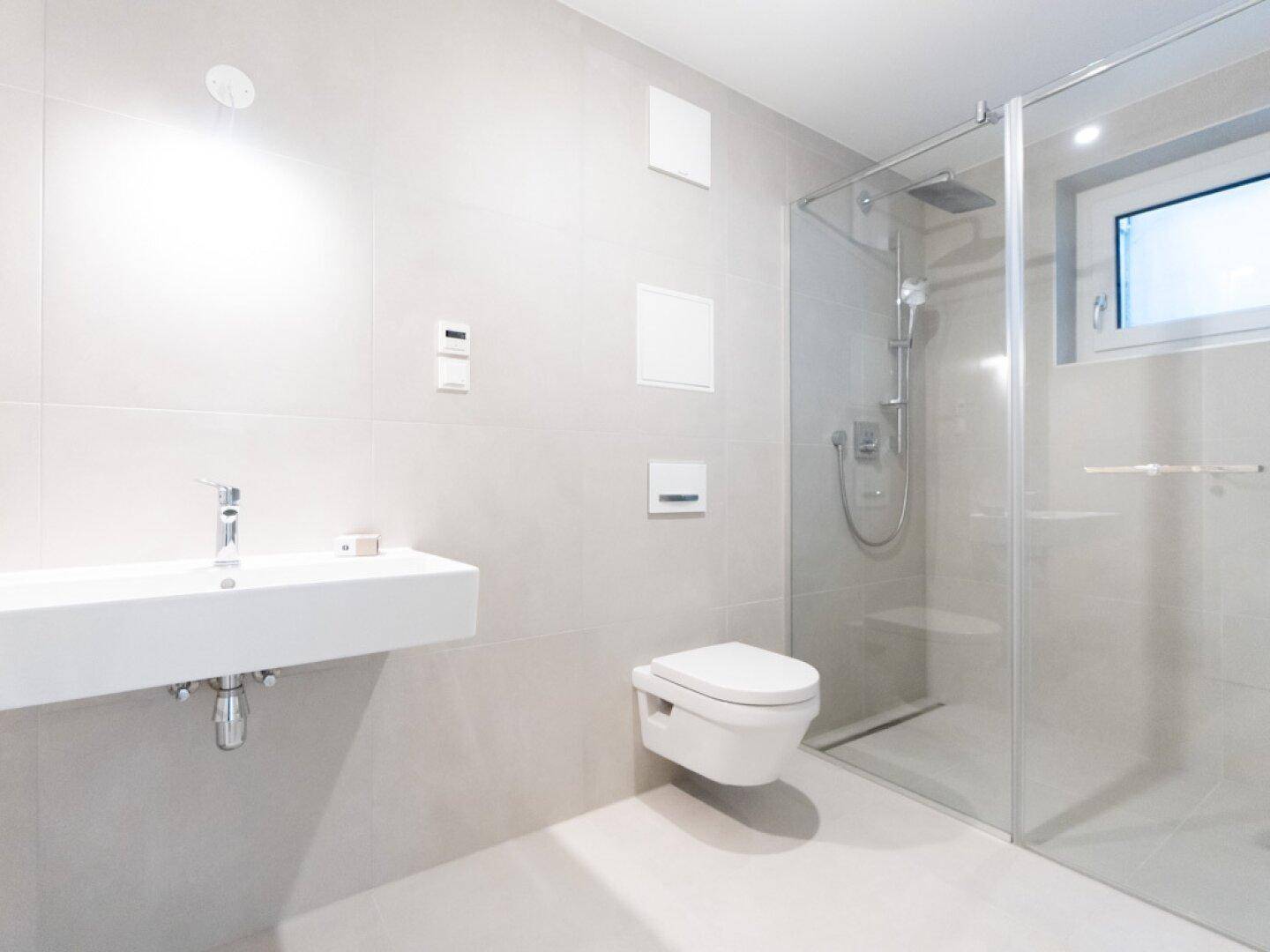 Modernes Badezimmer mit ebenerdiger Dusche, Einzelwaschbecken und Fenster für Tageslicht.