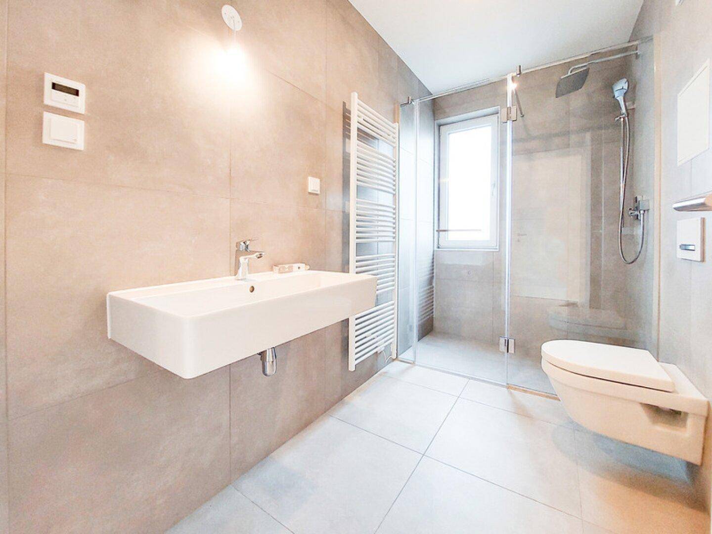 Modernes Badezimmer mit begehbarer Dusche, Wand-WC, Einzelwaschbecken und beheiztem Handtuchhalter.