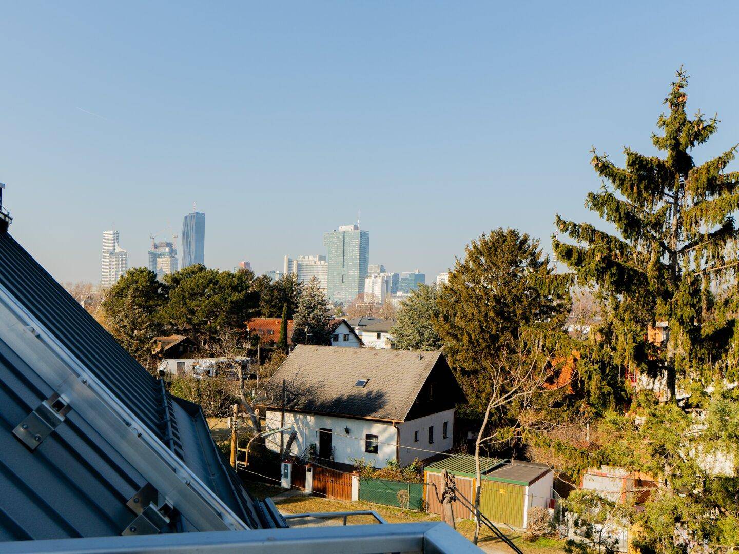 Weitblick auf die Stadt und die umliegende grüne Landschaft von einer erhöhten Position.