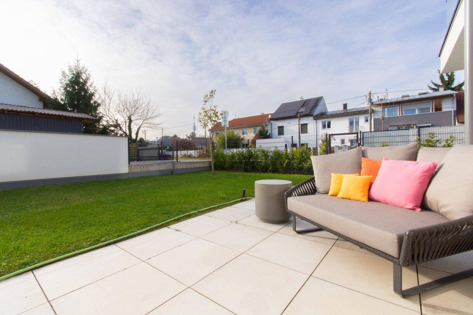 Geräumige Terrasse mit Gartenmöbeln und angrenzendem Rasenbereich.