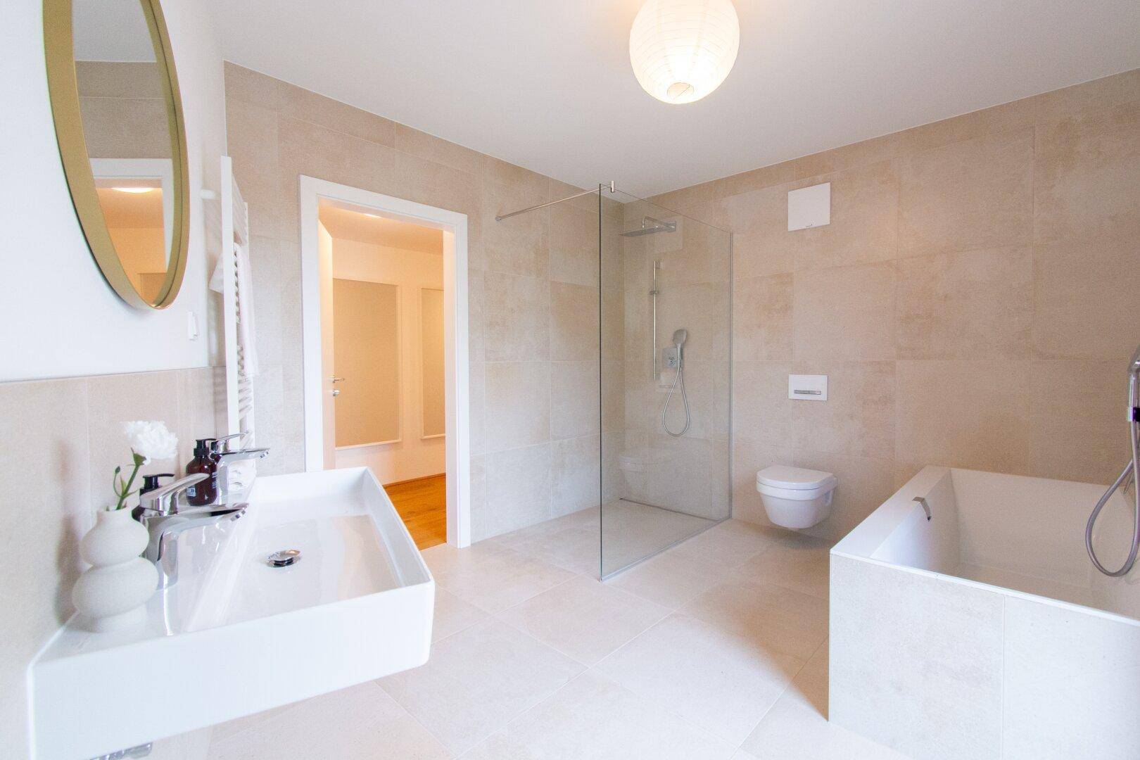 Modernes Badezimmer mit Badewanne, ebenerdiger Dusche und großem Waschbecken.