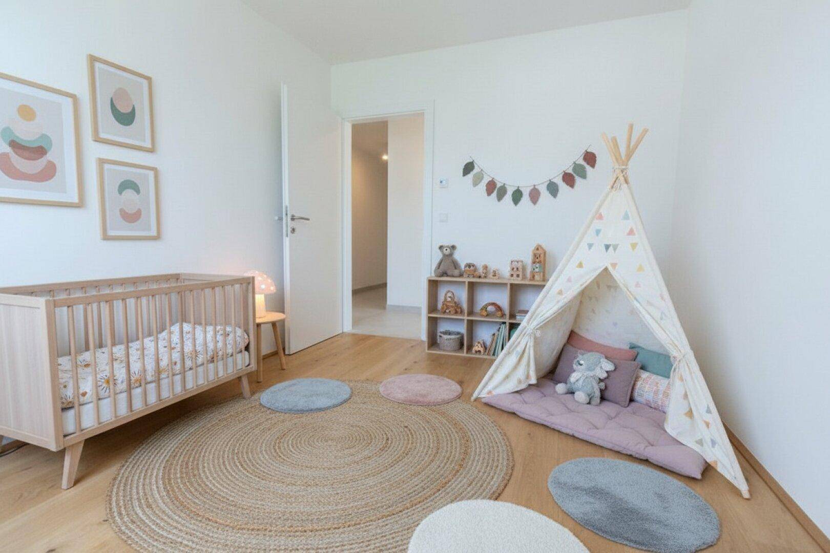 Helles Kinderzimmer mit Holzboden, Babybett und Spielzelt, liebevoll eingerichtet für die Kleinsten.