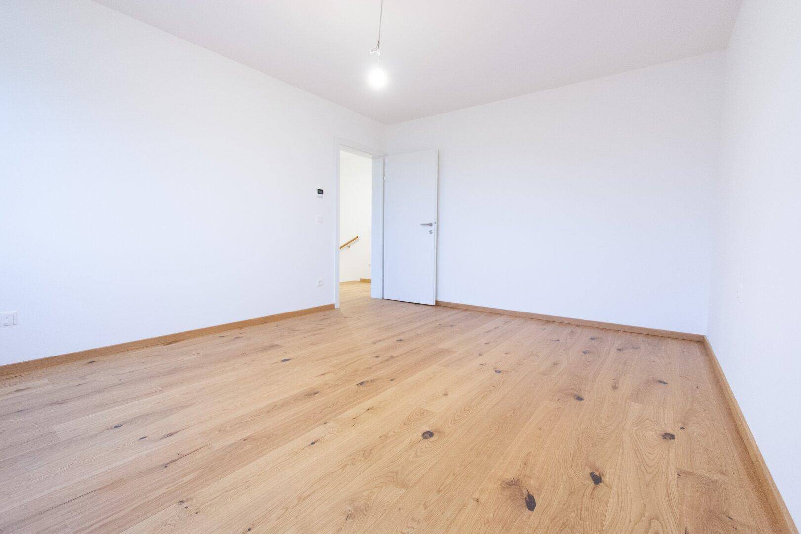 Geräumiges Schlafzimmer mit neuem Holzparkettboden und weiß gestrichenen Wänden, bereit zum Einzug.