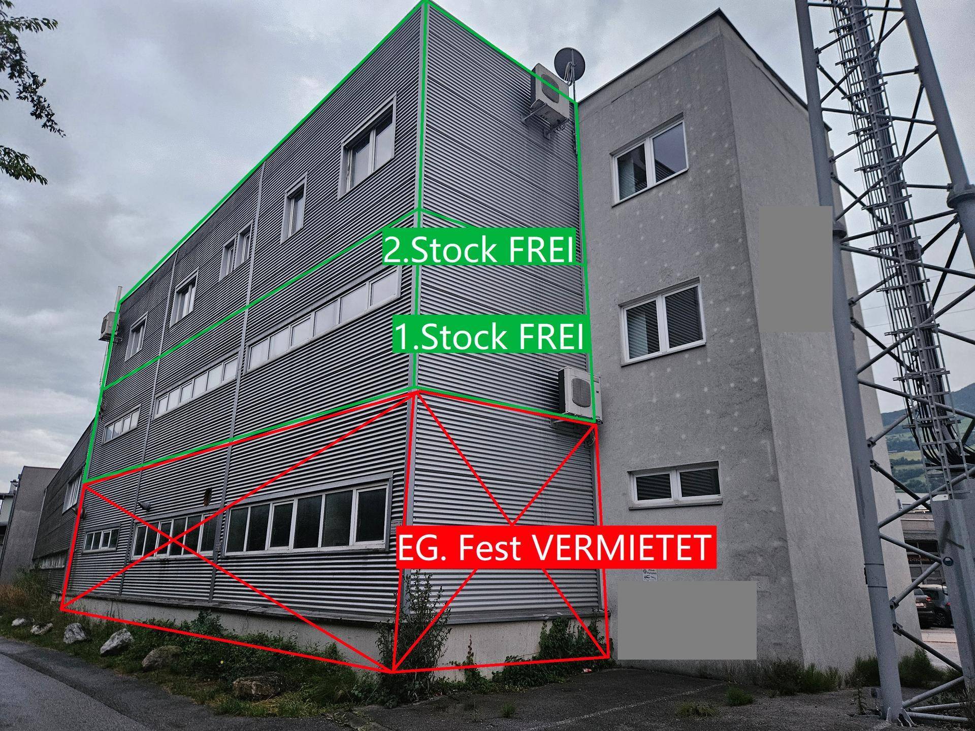 Seitenansicht des Gewerbegebäudes mit Wellblechfassade und Hinweisen zu freien Stockwerken.