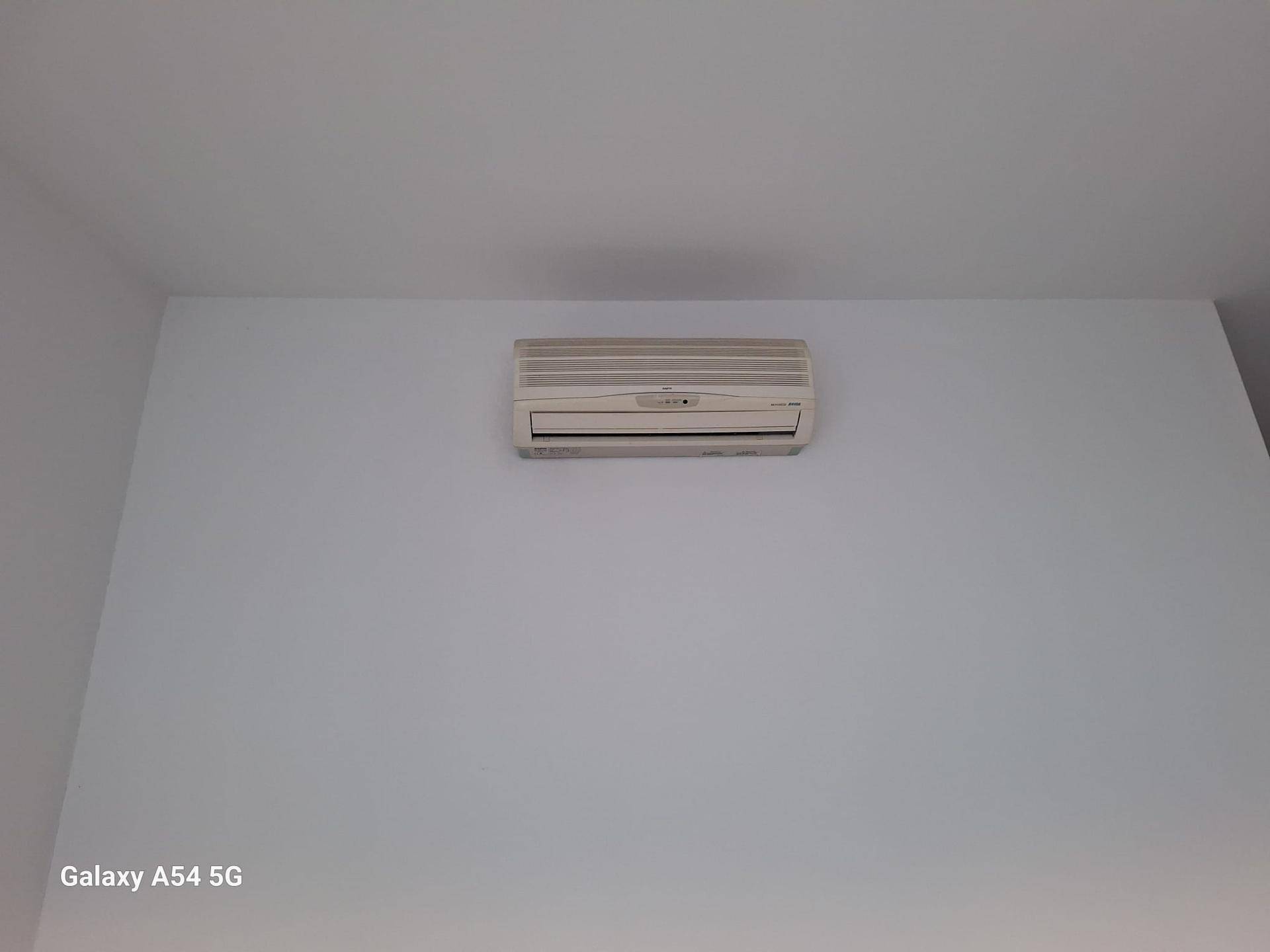 Eine Klimaanlage ist an einer sauberen, weißen Wand montiert und sorgt für angenehme Raumtemperatur.