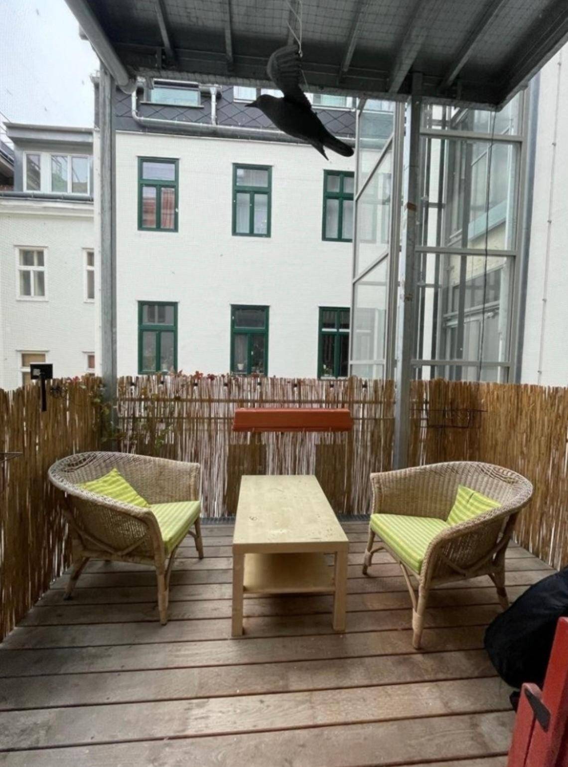 Gemütlicher Balkon mit Korbmöbeln und Sichtschutz, ideal zum Entspannen.