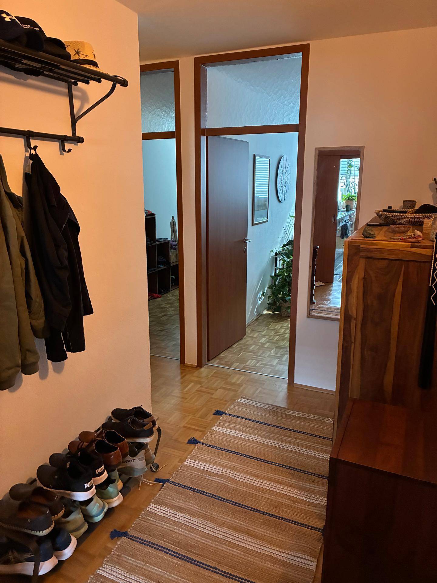 Heller Flur mit Holzparkettboden, Garderobe und Zugang zu weiteren Räumen der Wohnung.