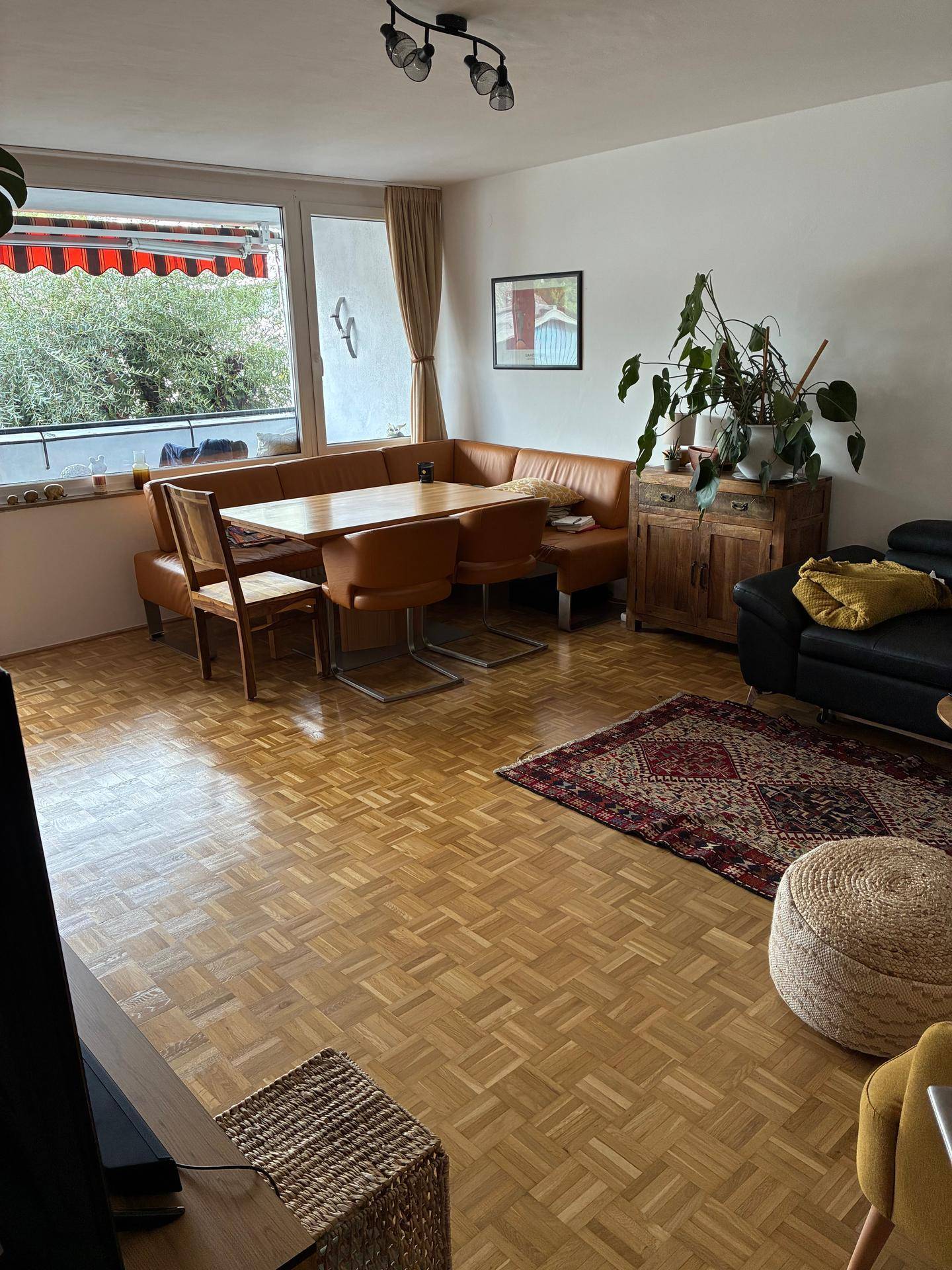 Gemütlicher Wohn-Essbereich mit Eckbank, Esstisch und Blick auf den Balkon.