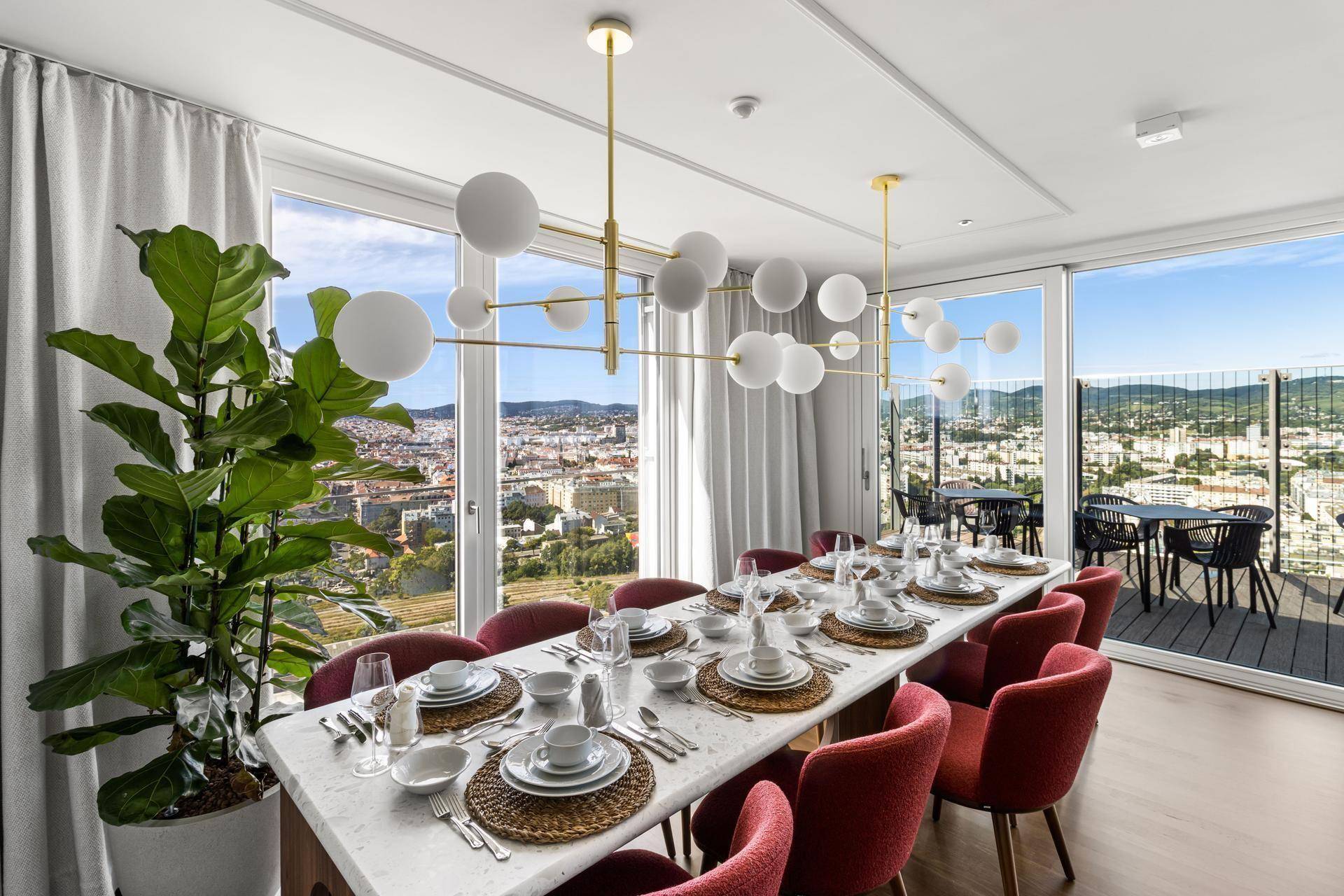 Eleganter Essbereich mit großem Tisch, modernen Leuchten und Panoramablick über die Stadt.