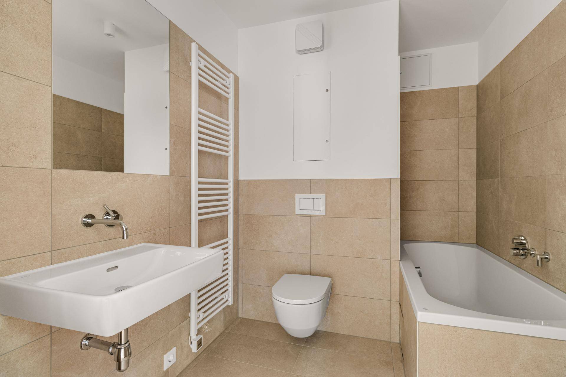 Modernes Badezimmer mit beigefarbenen Fliesen, Waschbecken, Toilette, Badewanne und Handtuchheizkörper.