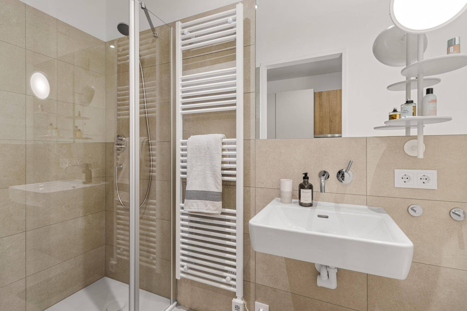 Modernes Badezimmer mit begehbarer Dusche, Einzelwaschbecken und beheiztem Handtuchhalter.