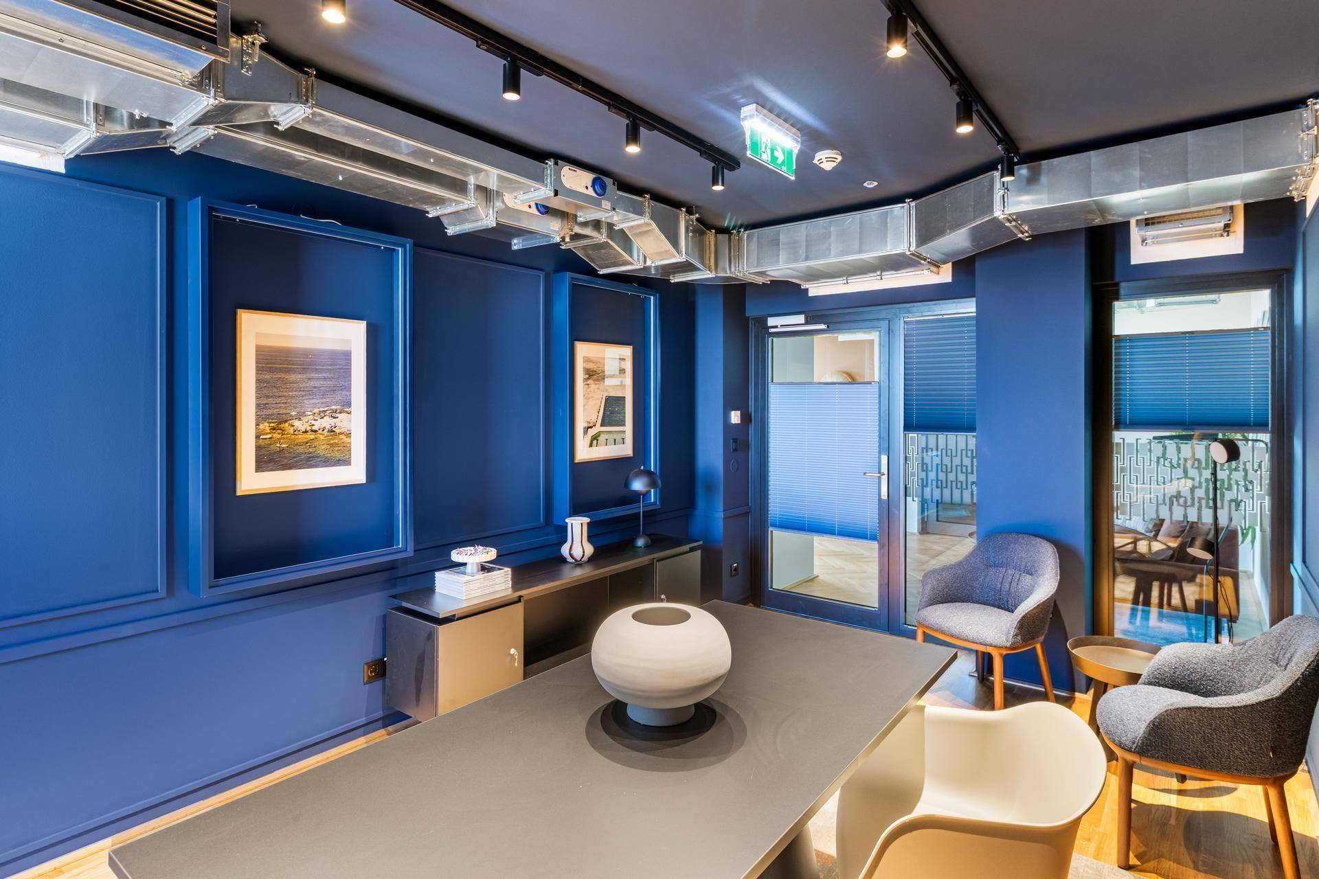 Modernes Büro oder Besprechungszimmer mit blauen Wänden und industriellem Design.