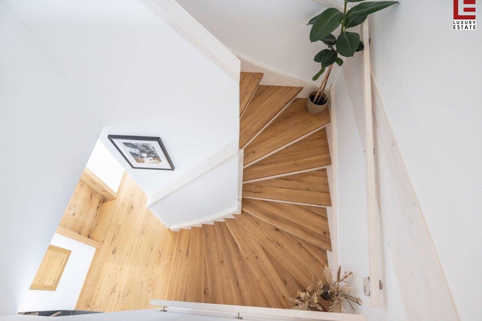 Moderne Holztreppe mit offenem Design, die die verschiedenen Ebenen des Hauses verbindet.