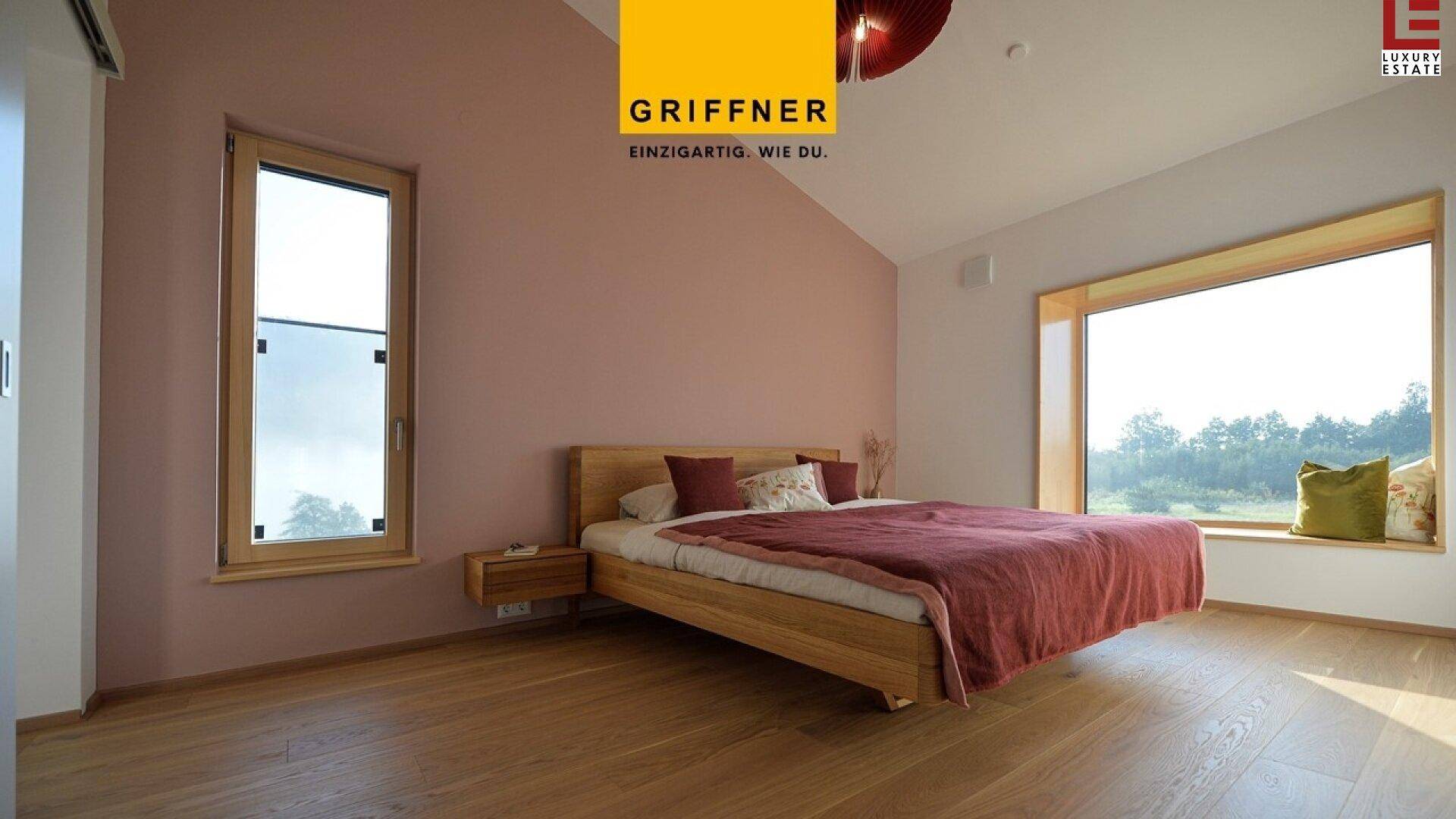 Modernes Schlafzimmer mit Holzbett, großen Fenstern und Blick auf die Landschaft.