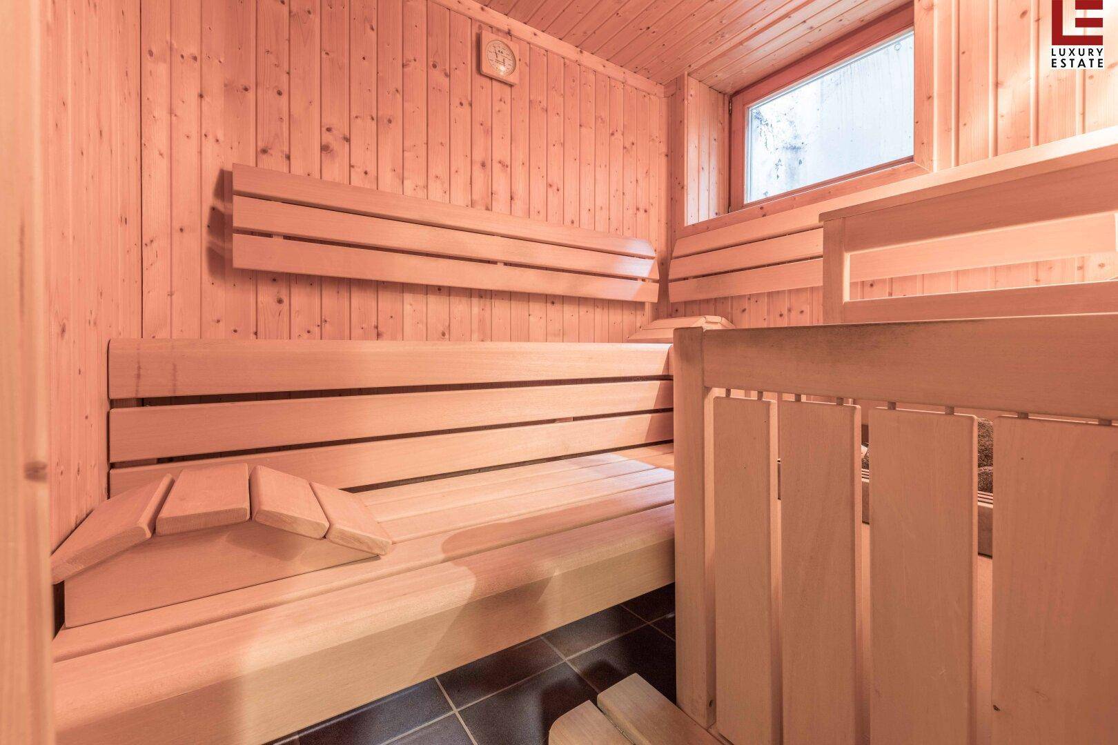 Traditionelle Holzsauna mit Sitzbänken und einem kleinen Fenster für Entspannung.
