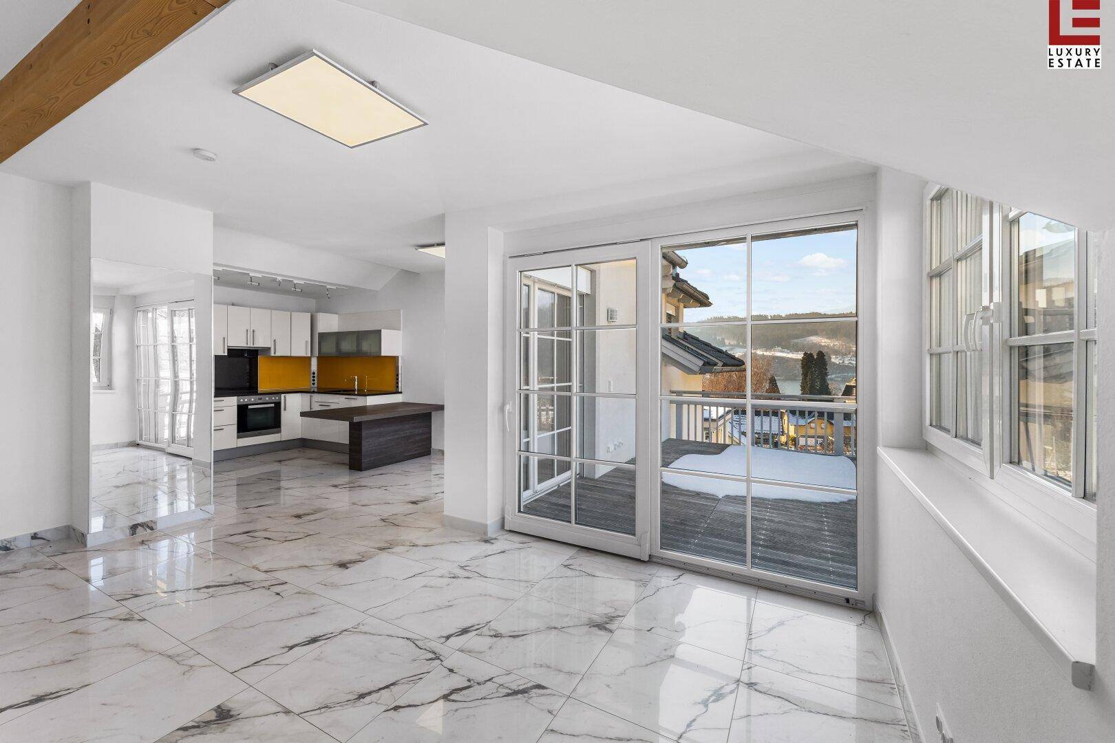 Geräumiger offener Wohnbereich mit glänzenden Marmorfliesen und Blick auf die umliegende Landschaft.