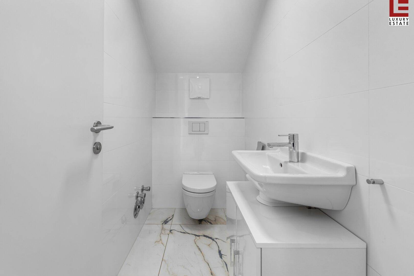 Sauberes Gäste-WC mit wandhängender Toilette, Bidet und modernen Armaturen.