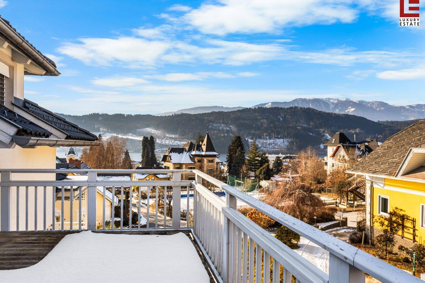 Großer Balkon mit Panoramablick auf die verschneiten Berge und den See.