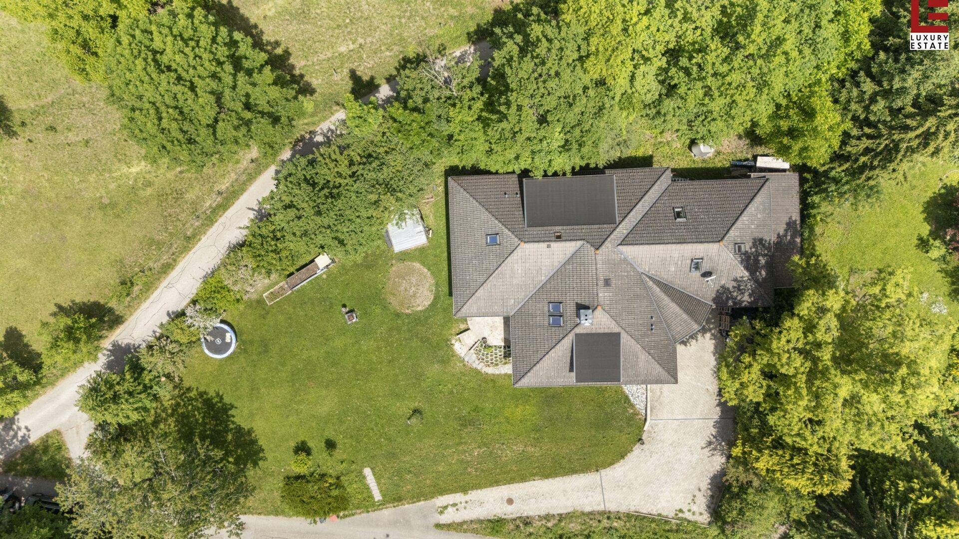 Vogelperspektive des Hauses mit Satteldach, Solarpaneelen und weitläufigem Grundstück.