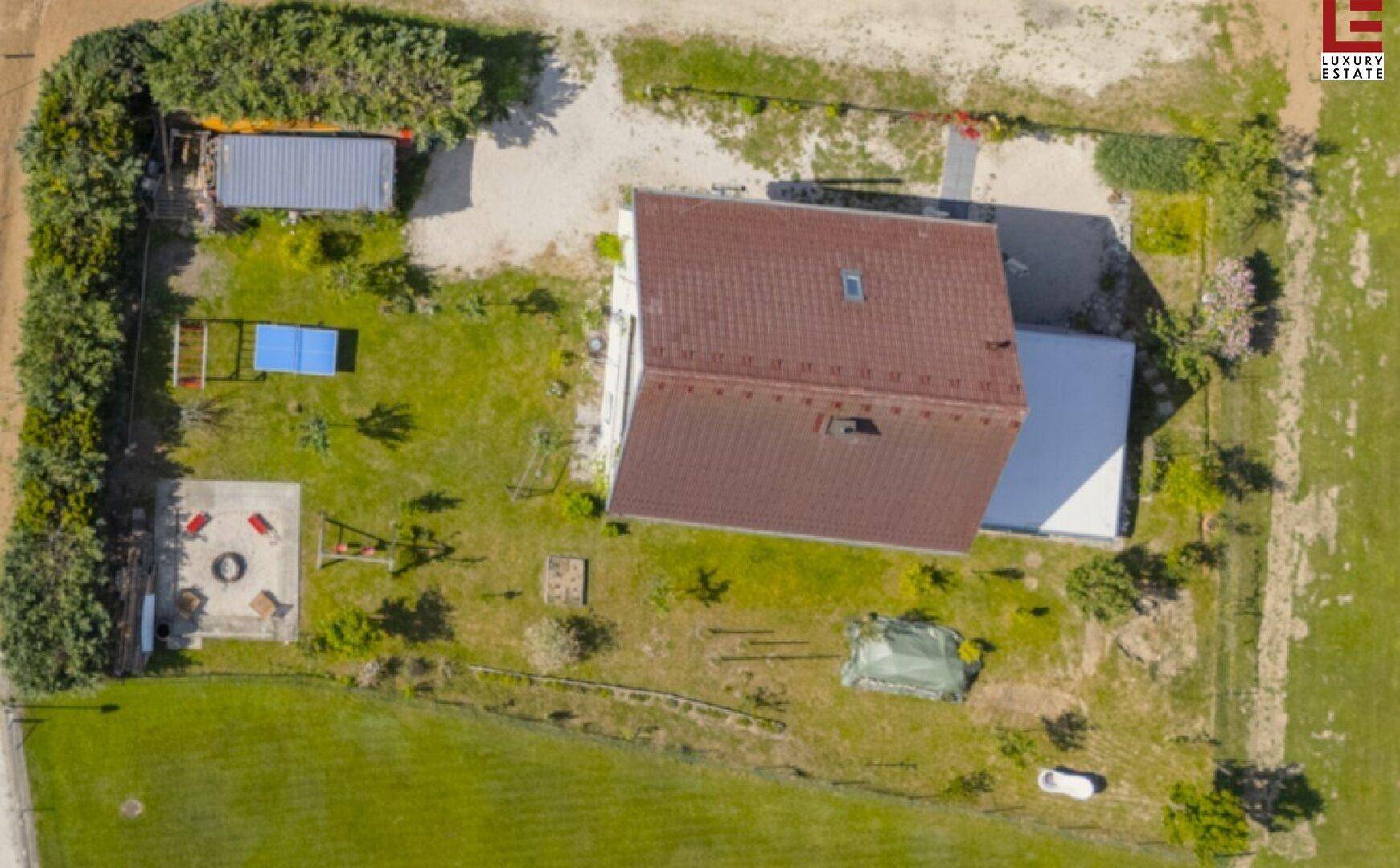 Vogelperspektive des Anwesens mit Haus, Garten und umliegender Landschaft.