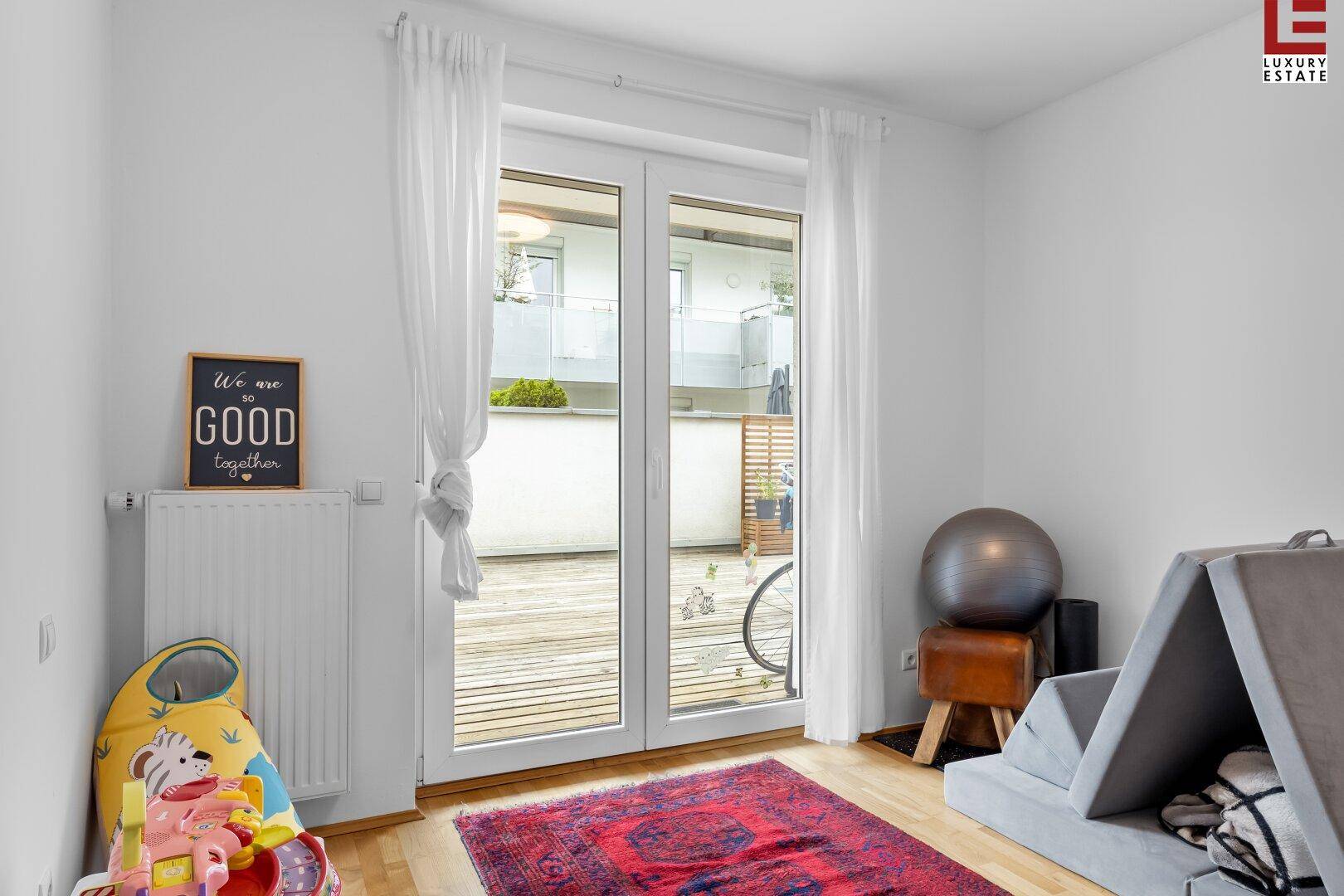 Helles Zimmer mit Zugang zur Terrasse, ausgestattet mit Heizkörper und Spielsachen.