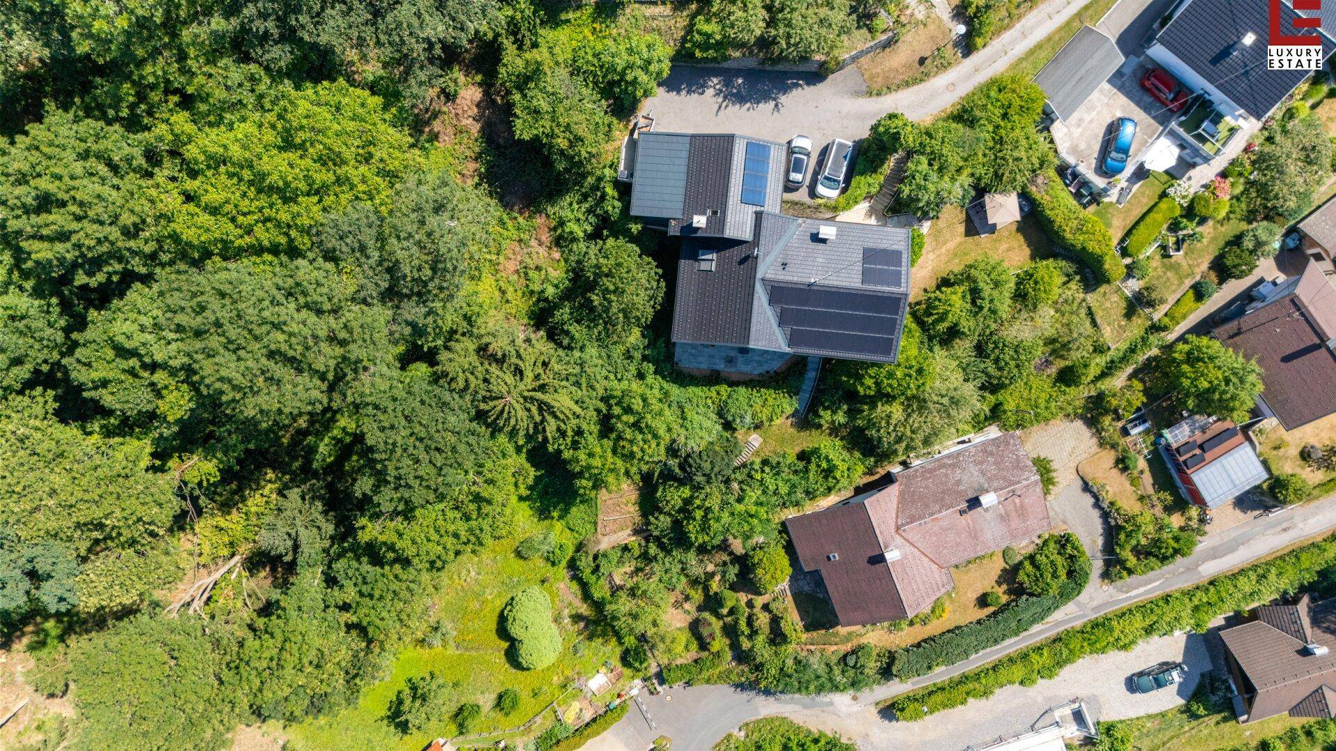 Vogelperspektive des Anwesens mit Photovoltaikanlagen auf den Dächern, eingebettet in grüne Natur.